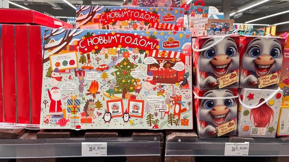 Новогодние сладкие подарки на полках в магазине.