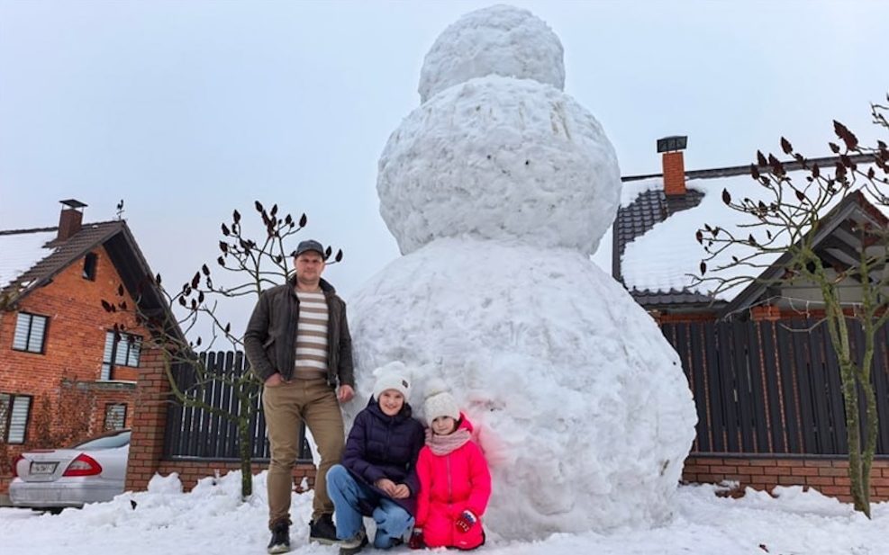Леонид Филанович вместе с дочками Миланой и Лианой на фоне гигантского снеговика в деревне Маньковичи Столинского района.